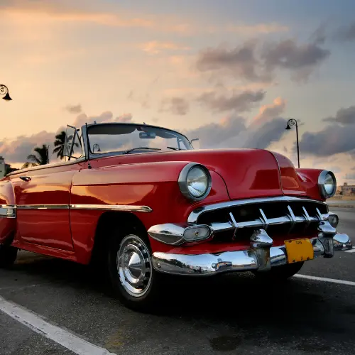 A classic car - brand unknown, with a red finish